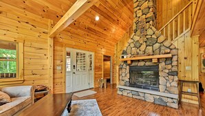 A log cabin interior with a stone fireplace, wooden walls, and a wooden ceiling. - Private Chester Home w/ Deck, Mins to Skiing! (Chester)