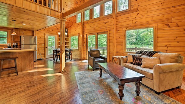 A spacious cabin with a kitchen, dining area, and a cozy living room with a large window overlooking the forest. - Private Chester Home w/ Deck, Mins to Skiing! (Chester)