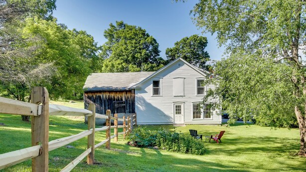 A two-story house with a front porch, a wooden fence, and a well-maintained lawn. - Manchester Center Retreat w/ Mtn View, Near Skiing (Manchester Center)