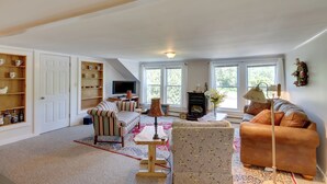A spacious living room with a high ceiling, a large window, and a cozy seating area. - Manchester Center Retreat w/ Mtn View, Near Skiing (Manchester Center)