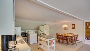 A compact kitchen with a coffee maker, microwave, and a dining area with wooden chairs and a table. - Manchester Center Retreat w/ Mtn View, Near Skiing (Manchester Center)