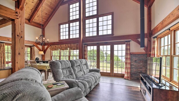 A spacious living room with a large sectional sofa, a dining area, and a fireplace.