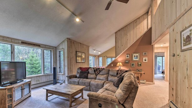 A spacious living room with a large window, a television, a sofa, and a coffee table. - Dover Home: 7 Mi to Mount Snow Grand Summit Resort (East Dover)
