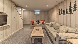A cozy room with a wooden floor, a sofa, a coffee table, and a TV on a stand. - Dover Home: 7 Mi to Mount Snow Grand Summit Resort (East Dover)