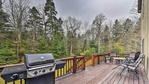 A wooden deck with a grill, outdoor furniture, and a view of a forest. - Dover Home: 7 Mi to Mount Snow Grand Summit Resort (East Dover)