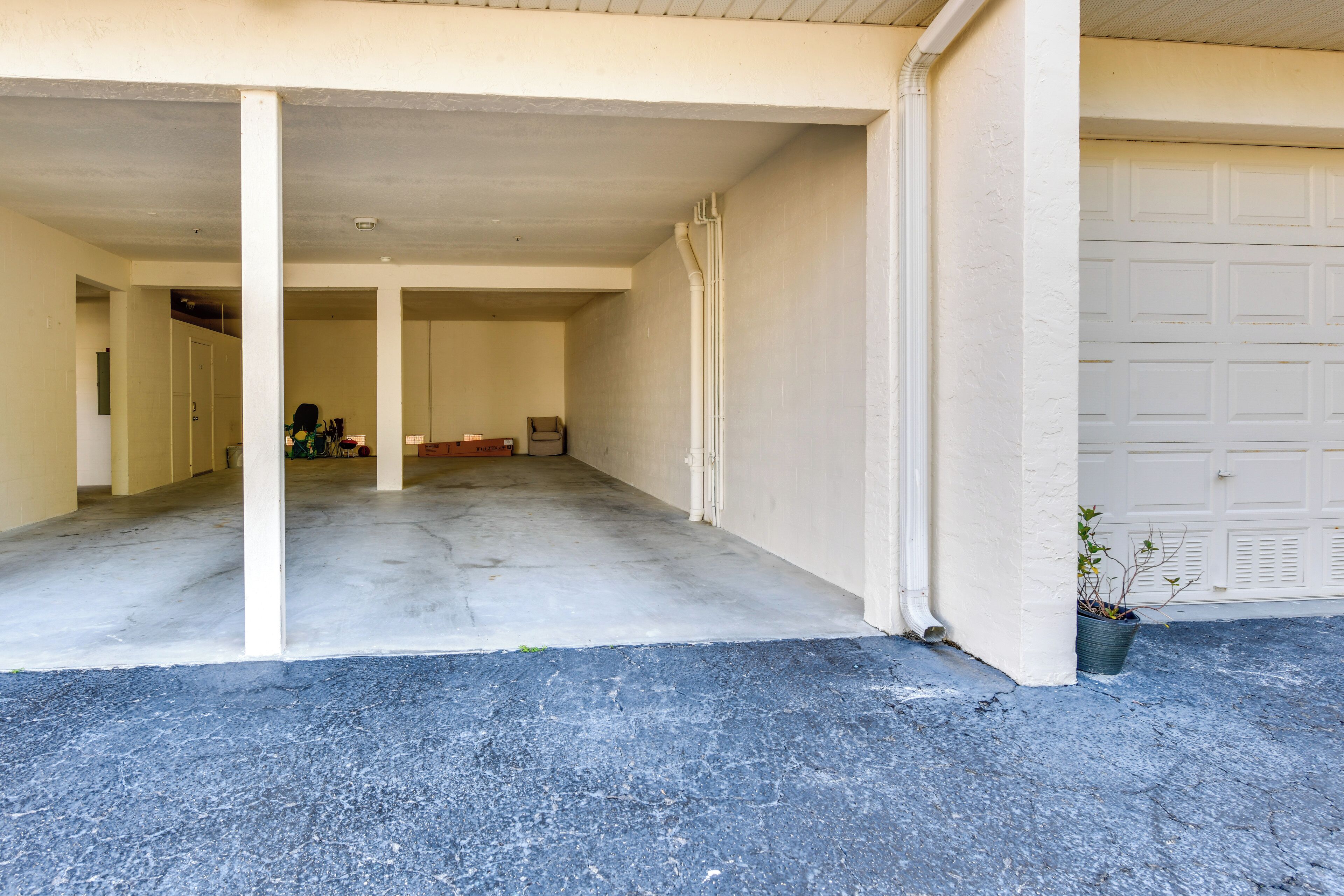 A garage with a concrete floor, white walls, and a white garage door.