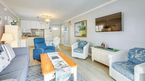 Ein Wohnzimmer mit Sofa, Sesseln, einem Couchtisch und einem Essbereich mit Tisch und Stühlen.
