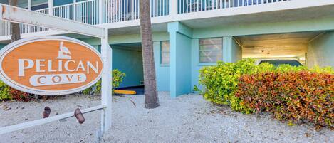 A hotel sign with a palm tree and a parking garage.