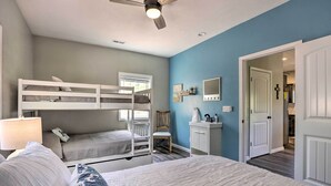 A bedroom with bunk beds, a desk, a chair, and a ceiling fan. - Lake Views, Fire Pit! Blue Cabin Ozarks Getaway (Camdenton)