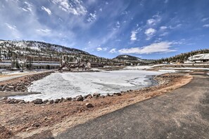 Un resort con una amplia zona abierta, edificios de varios pisos y montañas al fondo.