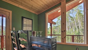 A room with a wooden ceiling, a green wall, a window with a view of trees, a framed picture on the wall, and a bar area with chairs and glasses. - < 1 Mi to Brian Head Resort: Mtn-view Gem w/ Deck (Brian Head)