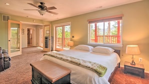 A bedroom with a bed, a ceiling fan, a window with a view, and a bench. - < 1 Mi to Brian Head Resort: Mtn-view Gem w/ Deck (Brian Head)
