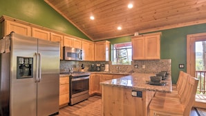 A kitchen with wooden cabinets, stainless steel appliances, granite countertops, and a wooden island with seating. - < 1 Mi to Brian Head Resort: Mtn-view Gem w/ Deck (Brian Head)