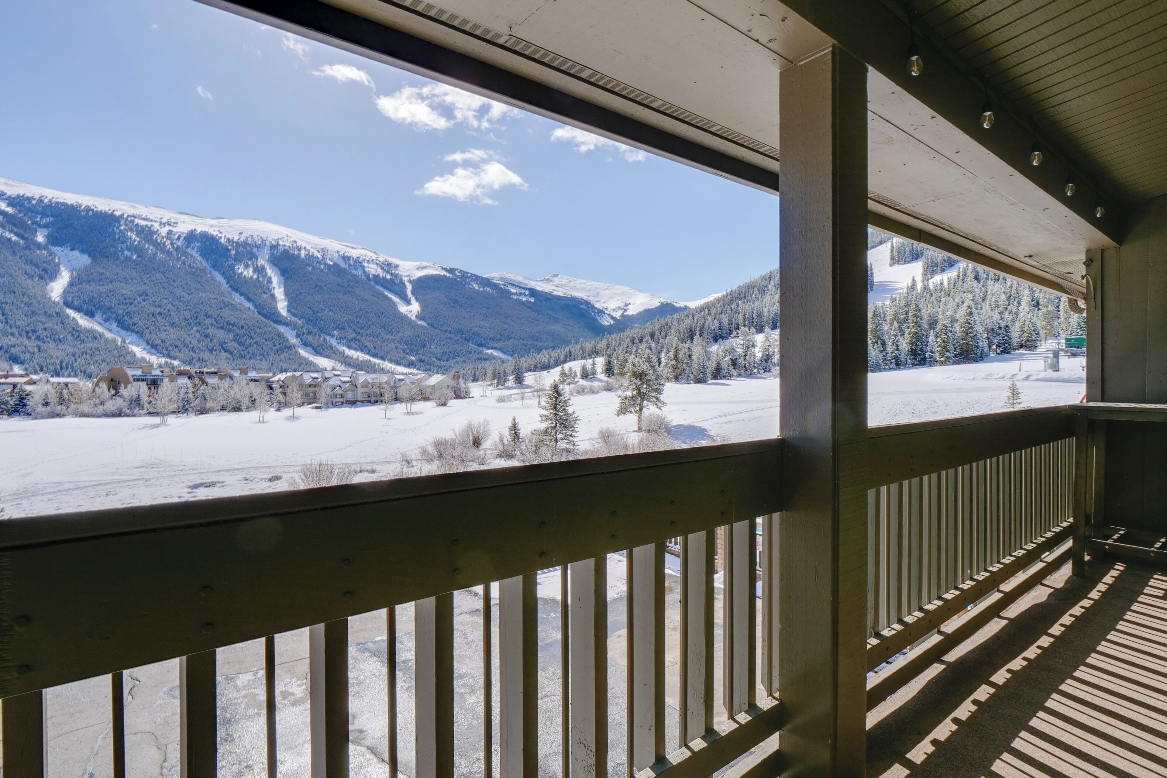 Ein Holzbalkon mit Blick auf eine verschneite Berglandschaft.