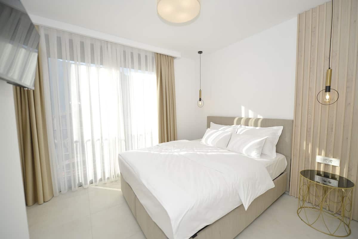 Un dormitorio moderno con una cama grande, una mesita de noche y una lámpara colgante.