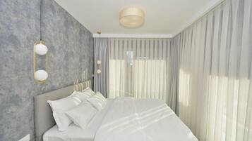 Quarto moderno com uma cama grande, cabeceira e luminária fixada na parede.