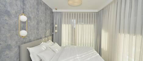 A modern bedroom with a large bed, a headboard, and a wall-mounted light fixture.