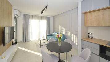 Departamento Deluxe, 1 cama Queen size y sofá cama, balcón, vista a la bahía | Área de sala de estar | Smart TV de 55 pulgadas con canales digitales, televisión y Netflix