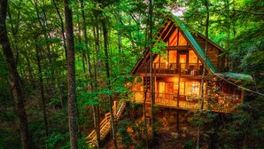 Una baita con facciata in legno, un balcone e una scala che conduce all'ingresso.