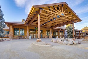 A lodge with a large covered entrance, stone pillars, and a stone fireplace. - The Inn at Silver Creek Resort Retreat w/ Balcony! (Granby)
