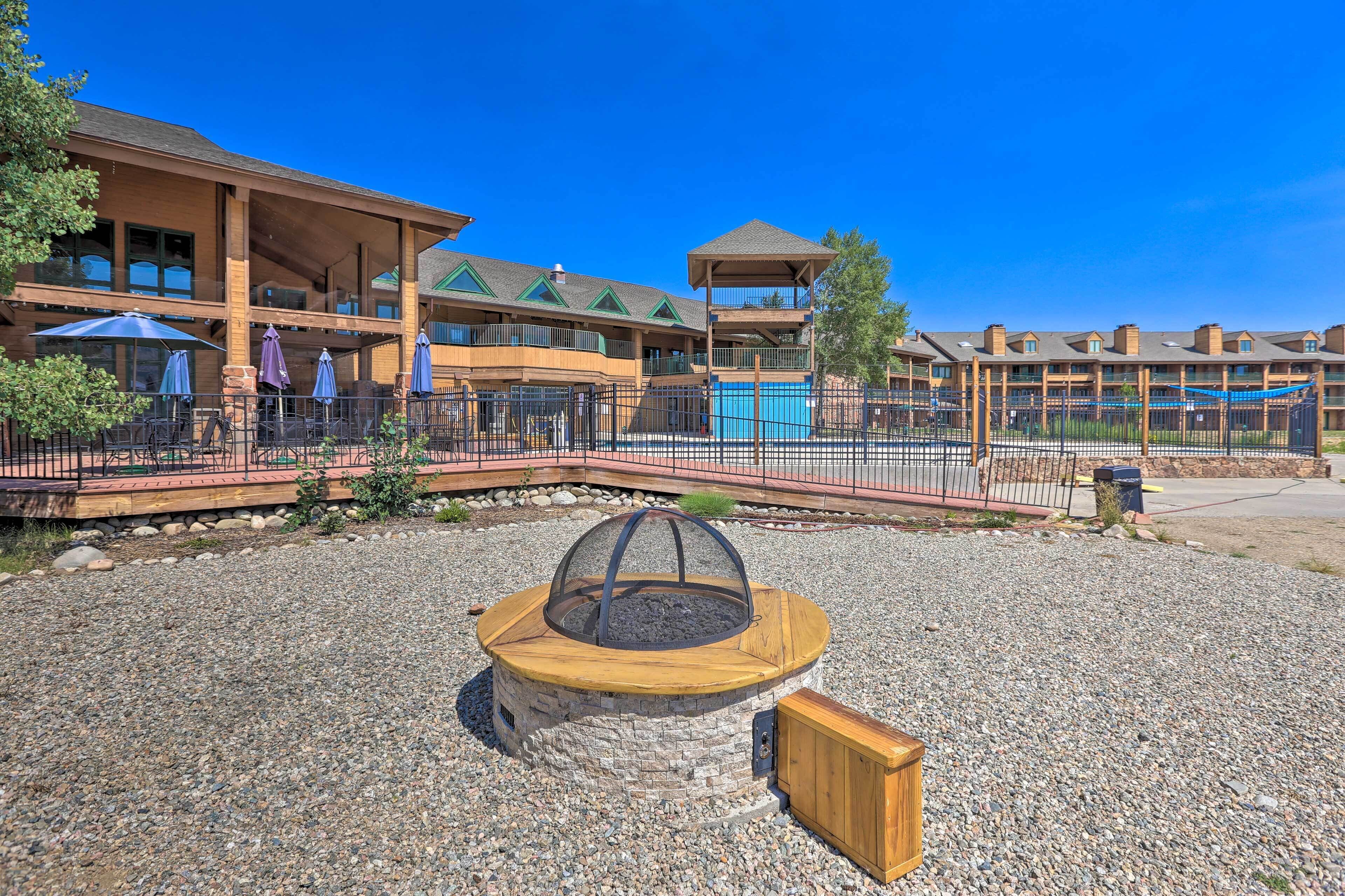 A hotel with outdoor seating, a fire pit, and a pool area.