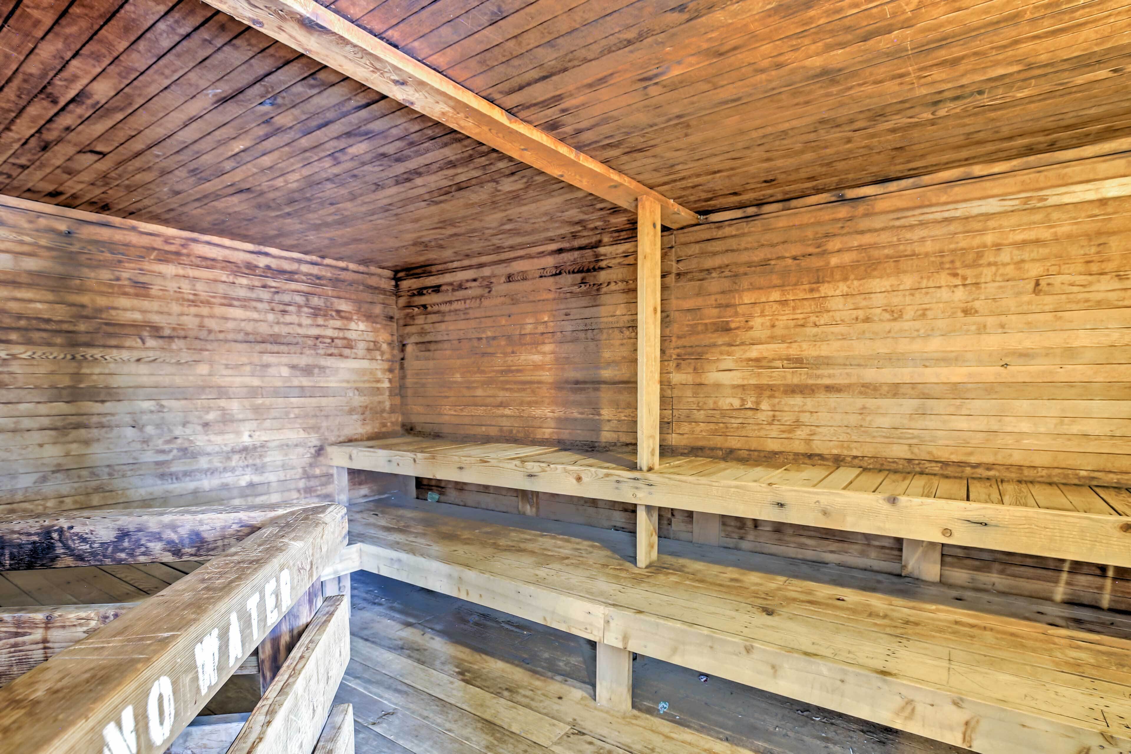 A wooden interior with multiple wooden benches and a 'NO WATER' sign.