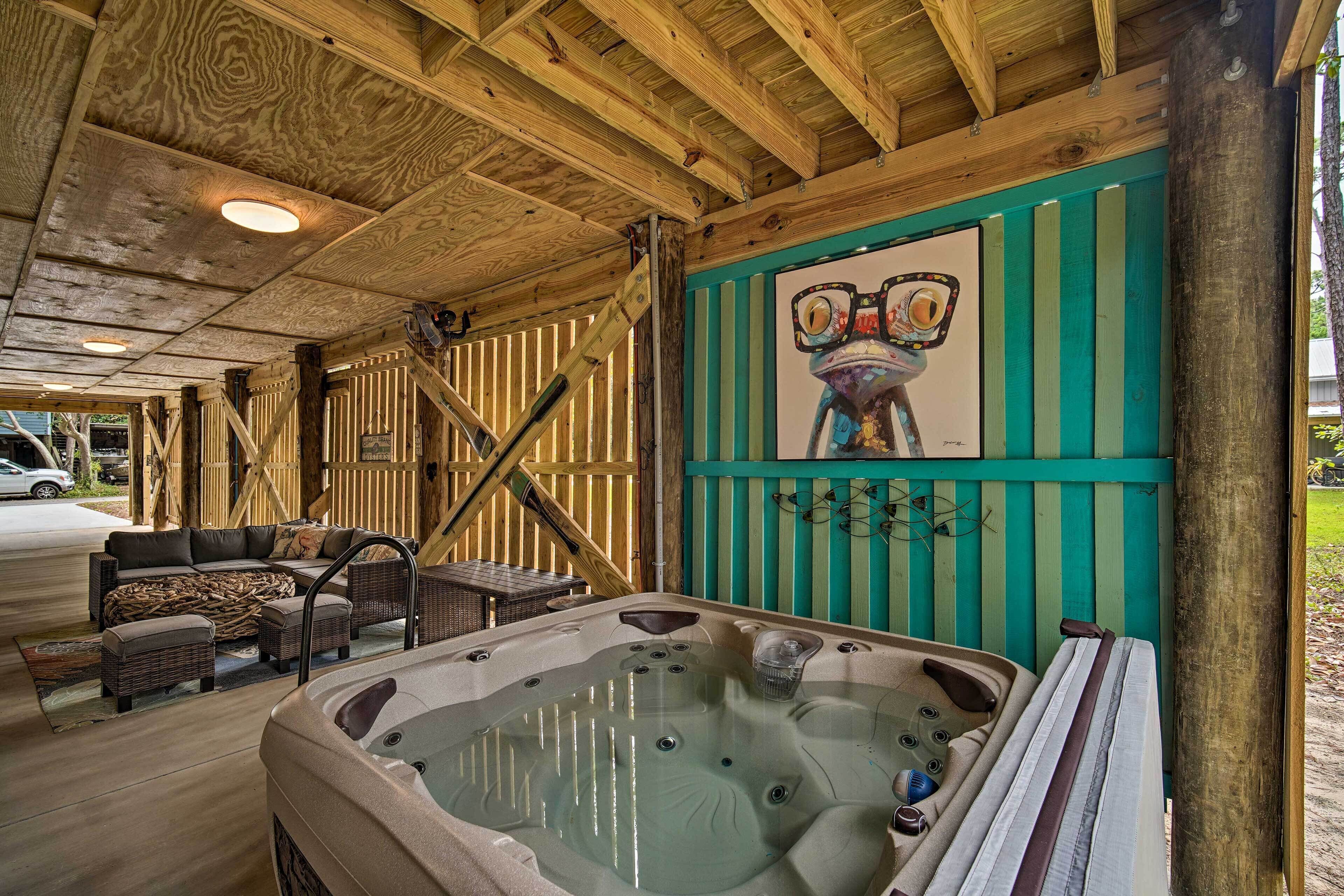 A wooden deck with a hot tub, outdoor furniture, and a mural.