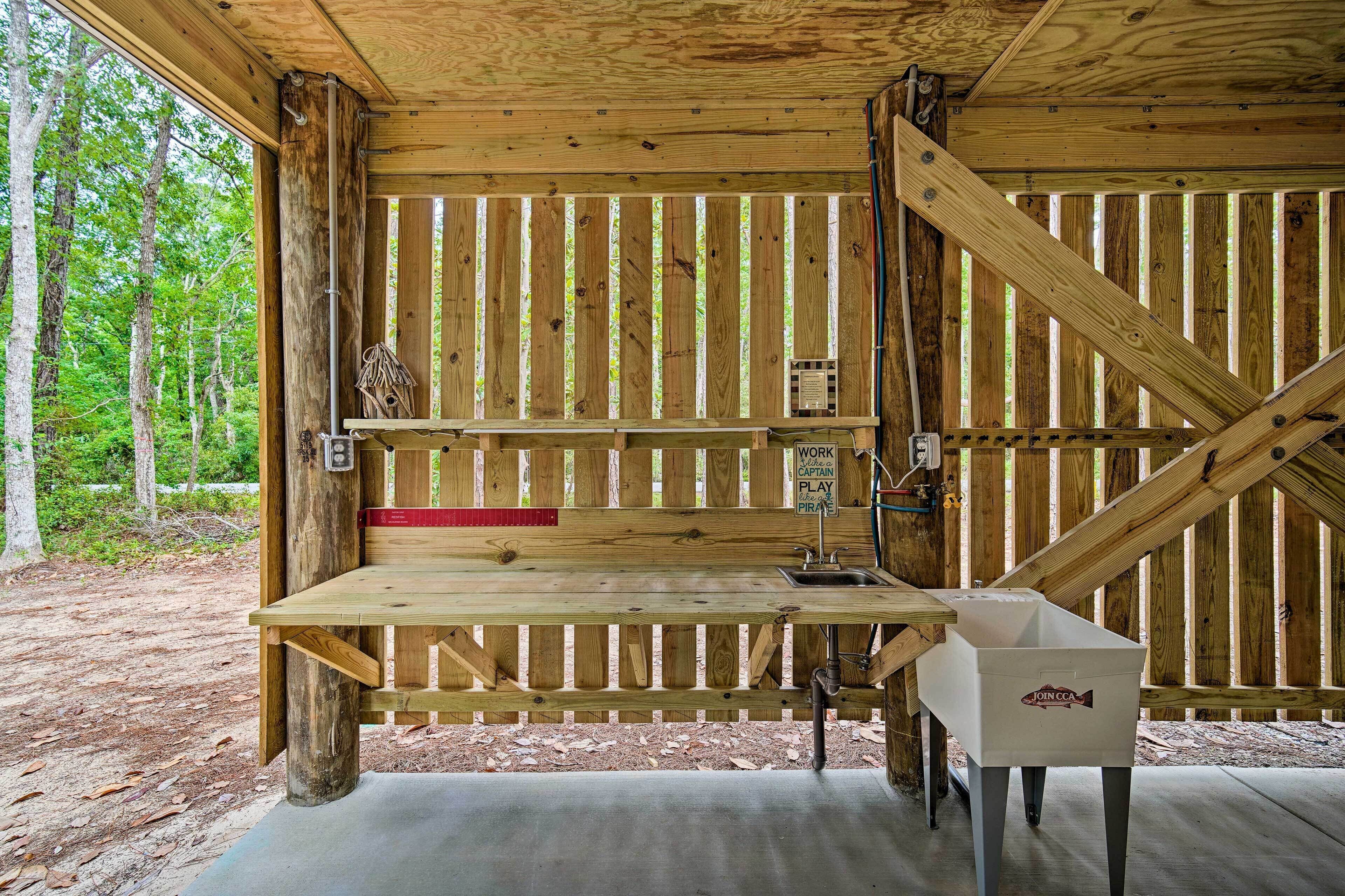 A wooden cabin with a workbench, a sink, and a storage box labeled "JOIN CCA".