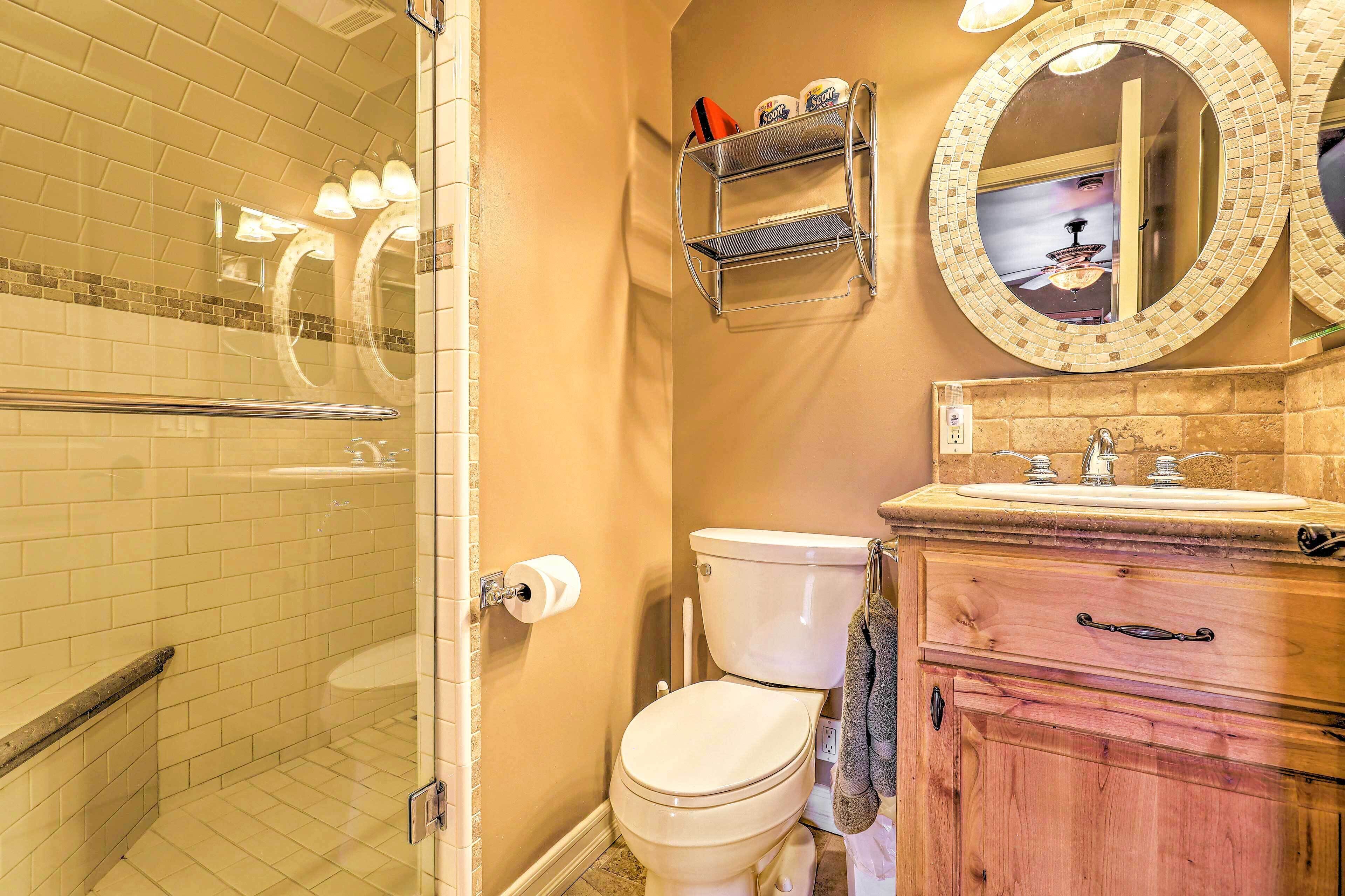 A bathroom with a toilet, sink, and a mirror with a decorative frame.