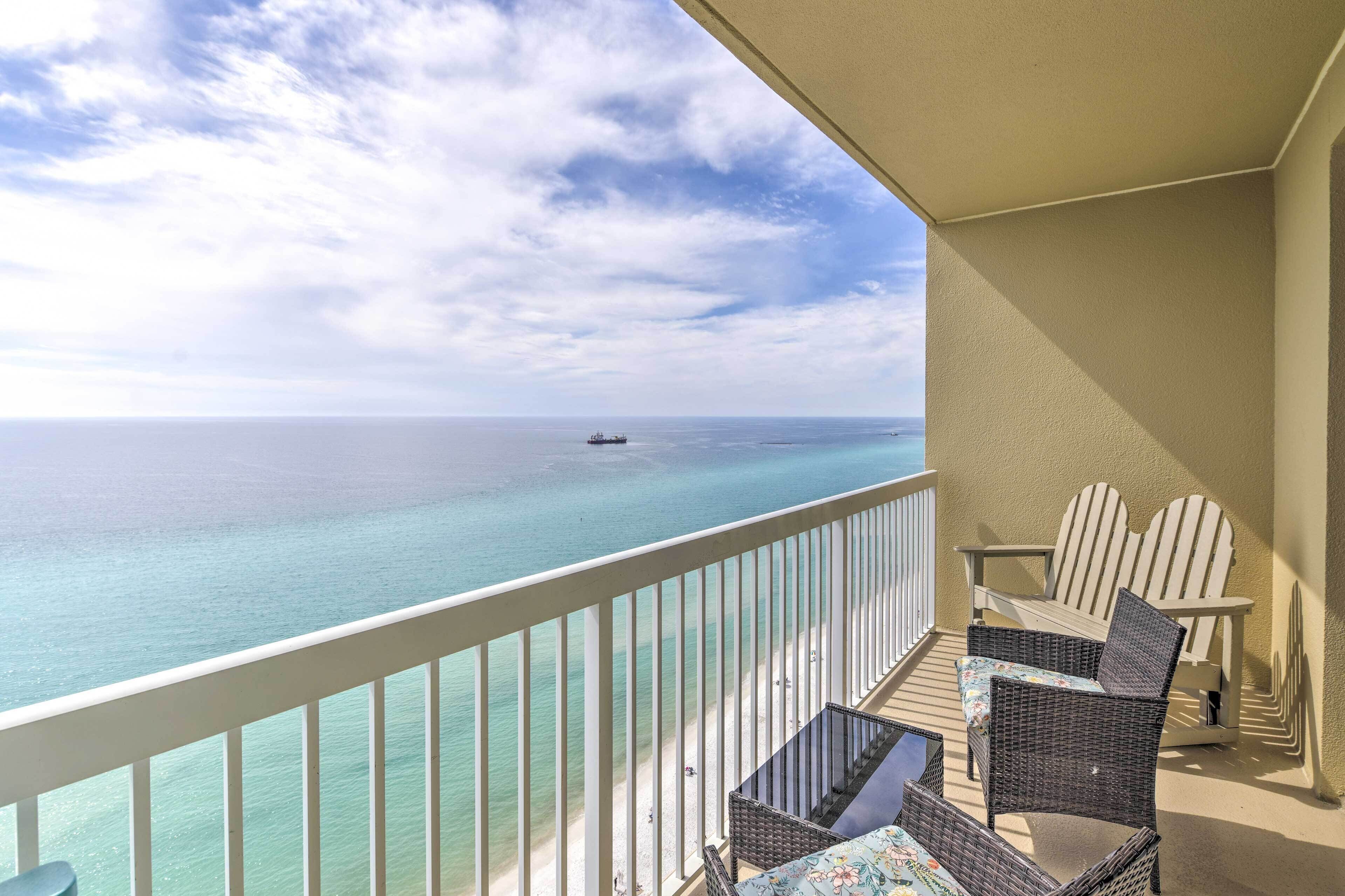 A balcony with wicker furniture and a view of the ocean.