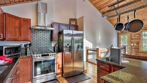 A modern kitchen with stainless steel appliances, wooden cabinets, and a brick backsplash. - Luxury Mountain Getaway in Fairplay w/ Deck! (Fairplay)