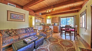 A spacious living room with a large sofa, a coffee table, and a patterned rug.