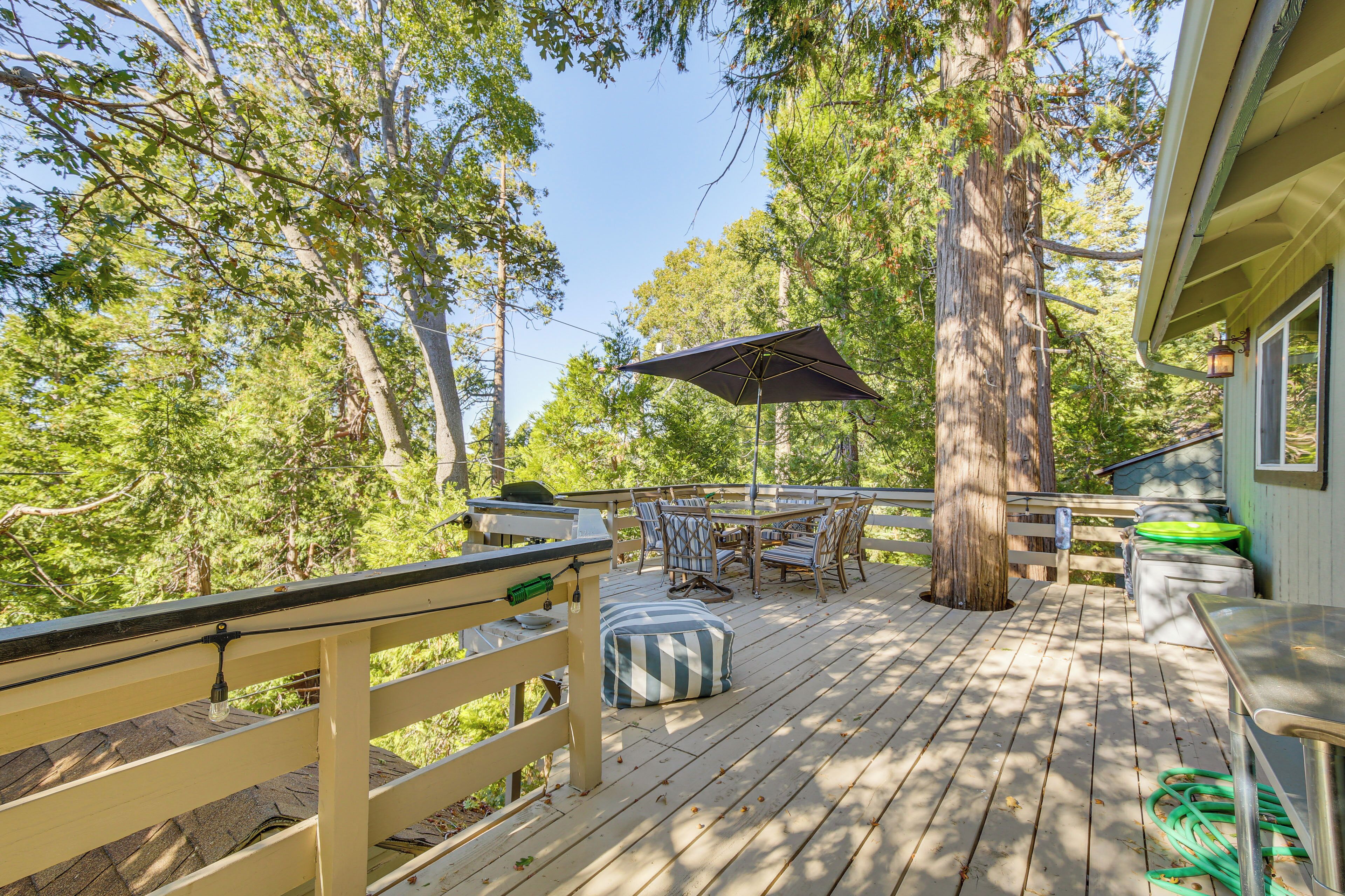 A wooden deck with outdoor furniture, a table, and chairs.
