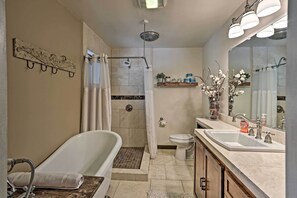 A bathroom with a bathtub, shower, toilet, and sink.