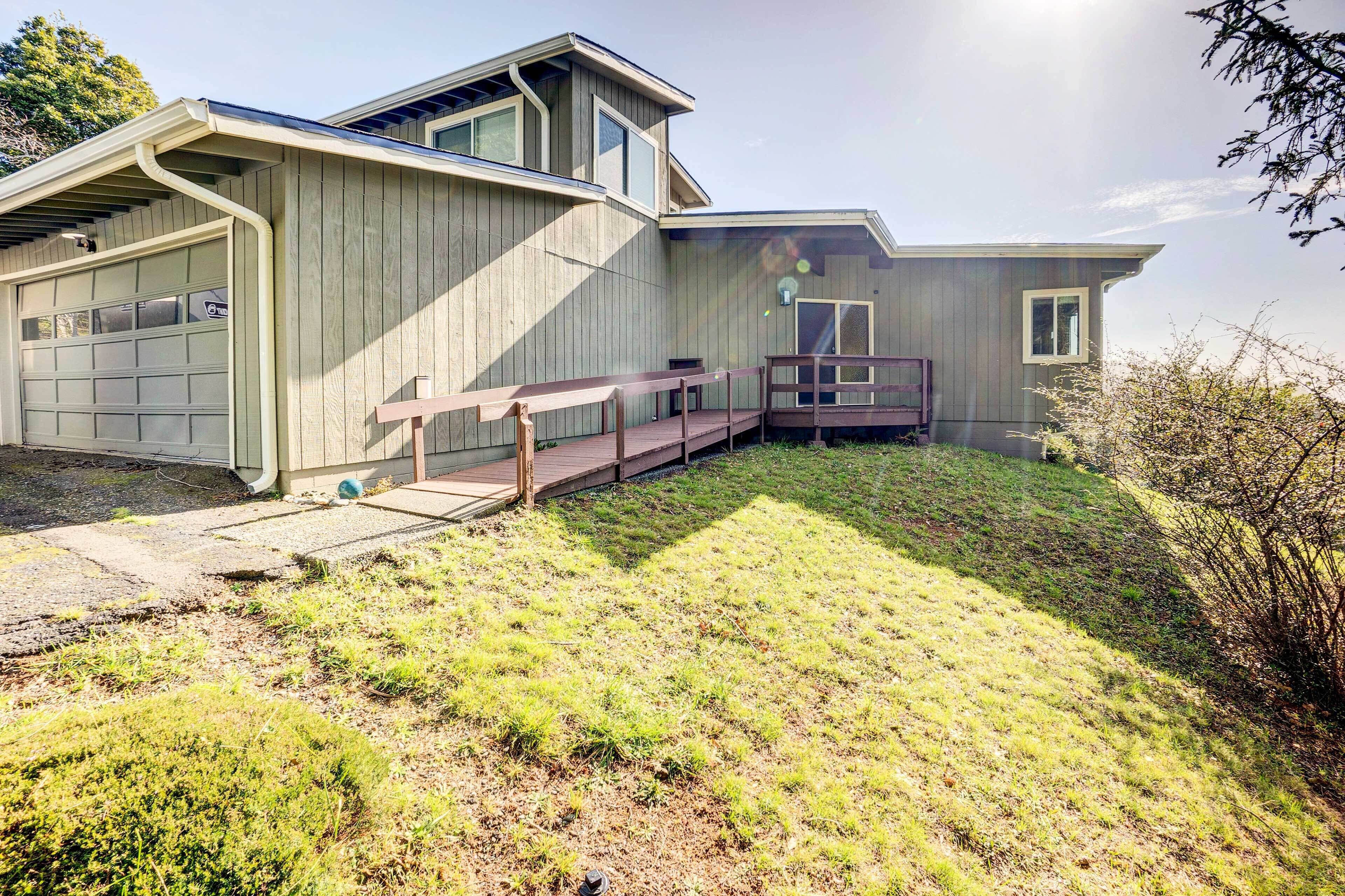 A modern house with a garage, a covered porch, and a small deck.