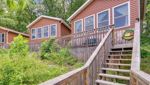 A wooden staircase leading to a cabin with a wooden deck and a sign indicating a fishing area. - 3 Cabins! Lakefront Reunion Retreat in Rocky Mount (Rocky Mount)
