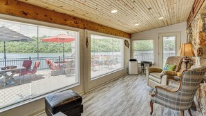 A spacious room with large windows, a wooden ceiling, and a view of a lake. - 3 Cabins! Lakefront Reunion Retreat in Rocky Mount (Rocky Mount)