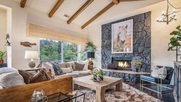 A cozy living room with a stone fireplace, a sofa set, and a coffee table. - Lake Arrowhead Retreat w/ Decks + Mountain Views! (Lake Arrowhead)