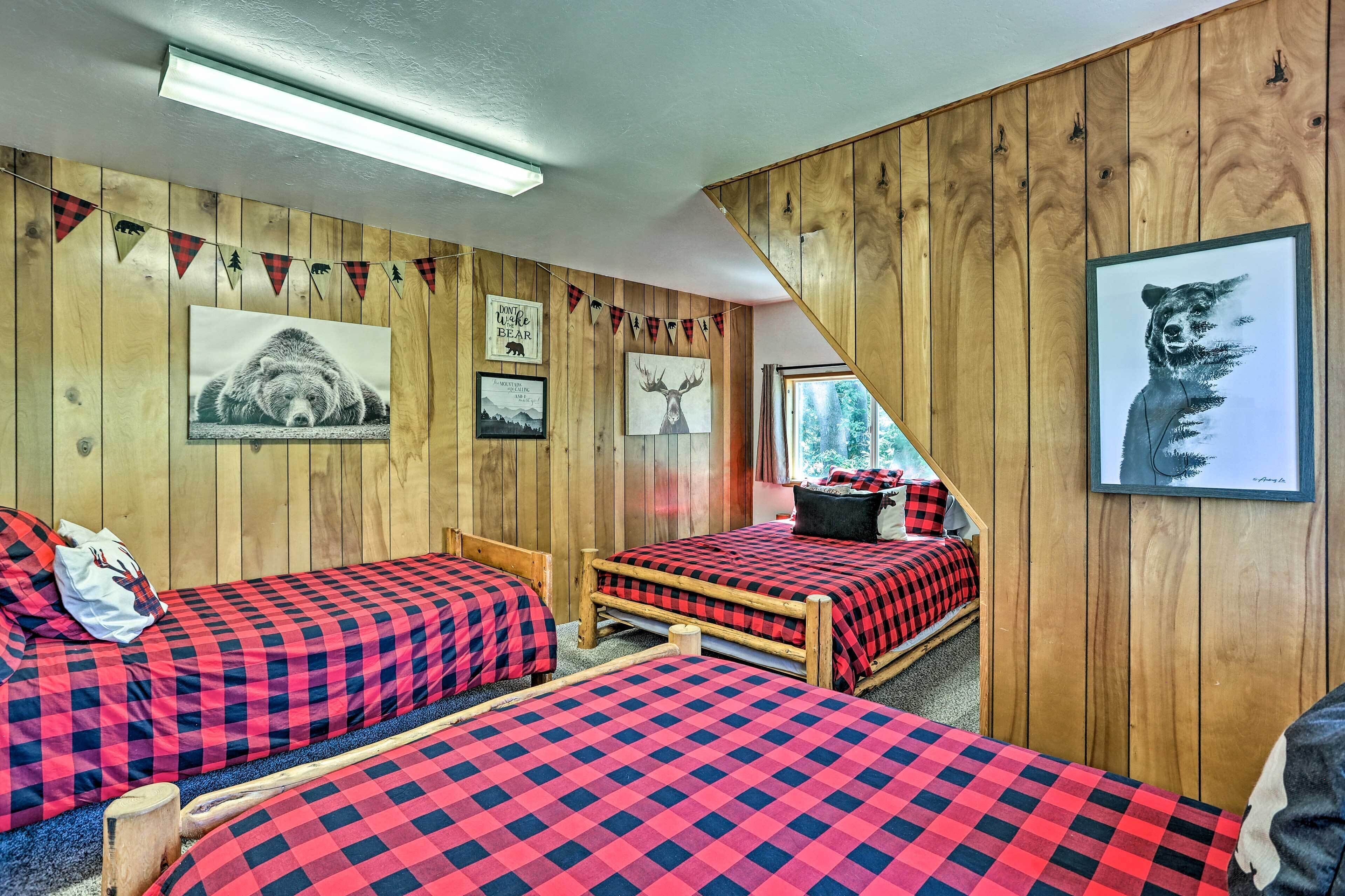 A cabin-style room with two beds, wooden walls, and various bear-themed decorations.