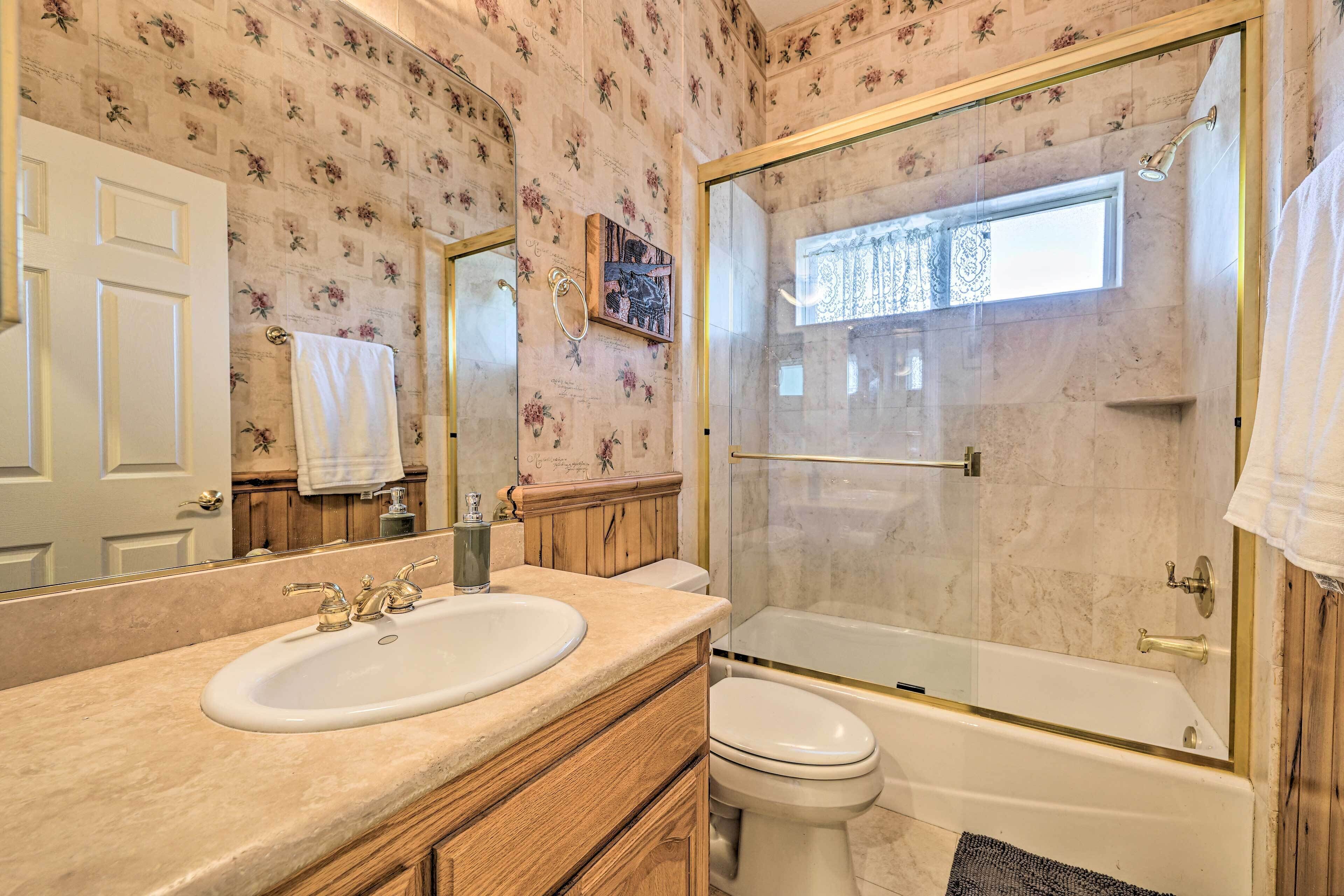 A bathroom with a sink, toilet, and glass-enclosed shower.