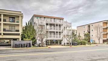 A multi-story building with balconies, a covered entrance, and a sign that reads "Sand Dunes."