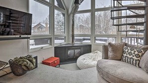 A cozy living room with a fireplace, large windows, and a comfortable seating area. - Vail Condo w/ Mtn-view Deck - Steps to Ski Shuttle (Vail)