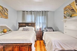 A bedroom with two beds, a wooden headboard, a white dresser, and a window with sheer curtains. - Boston Area Hub By Train Station, Gillette Stadium (Stoughton)