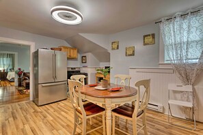 A modern kitchen with a central island, wooden flooring, and a dining area with a round table and chairs. - Boston Area Hub By Train Station, Gillette Stadium (Stoughton)