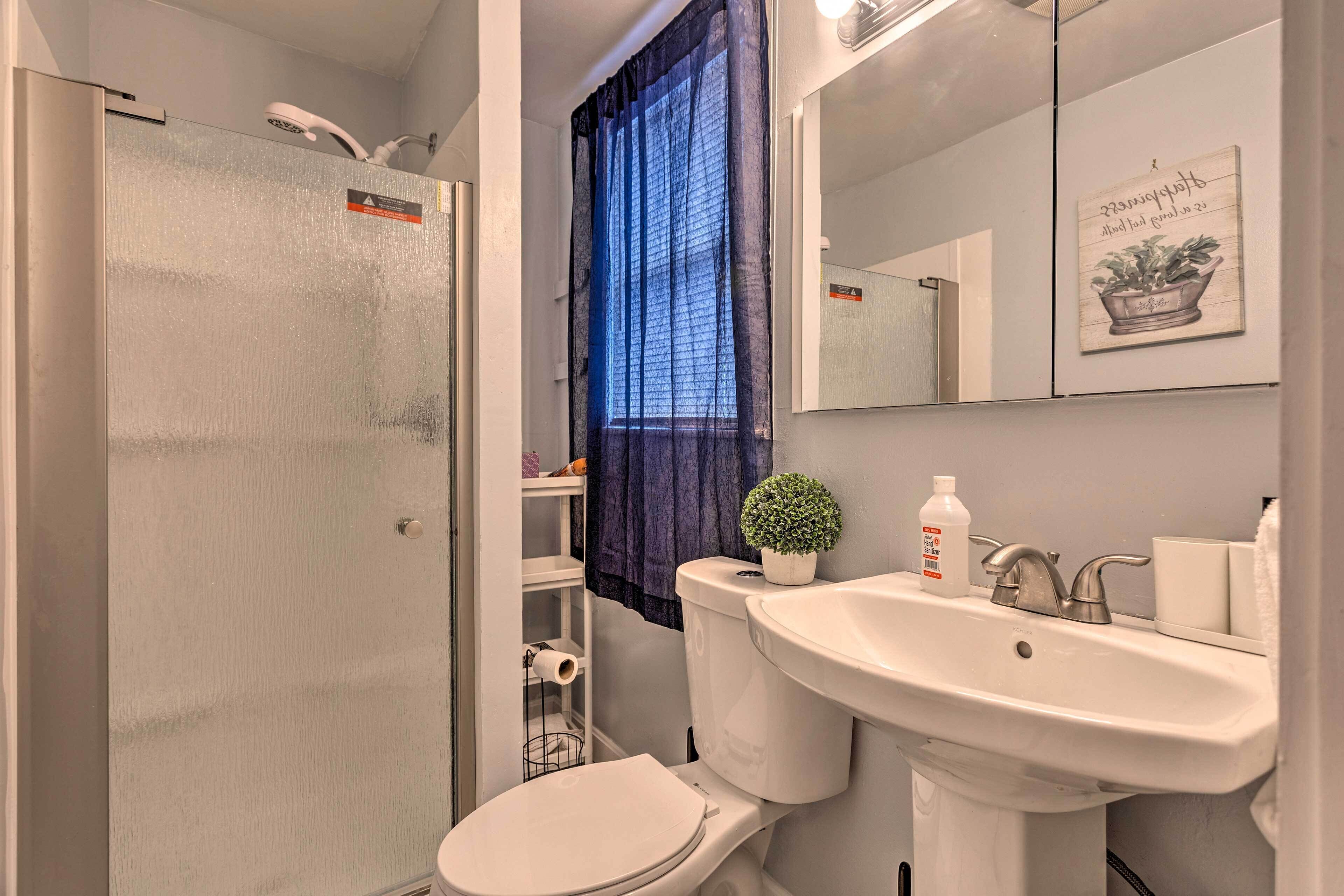 A bathroom with a toilet, sink, and shower.