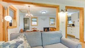 Un salon chaleureux avec un canapé à rayures, un lustre et un plafond en bois.