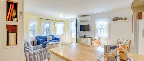 A bright kitchen with a wooden countertop, a blue sofa, and a striped armchair.