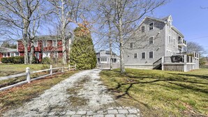 A pathway leading to a two-story house with a front porch and a small deck. - Multi-level Marion House: Loft, Deck + Ocean Views (Marion)