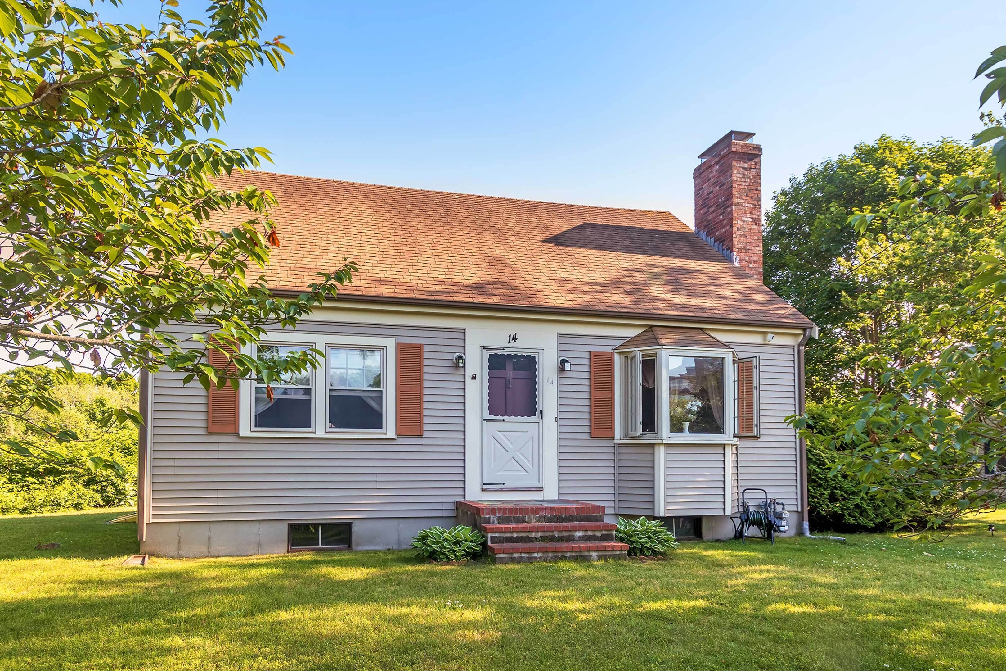 A single-story house with a chimney, a front door, and a small porch.