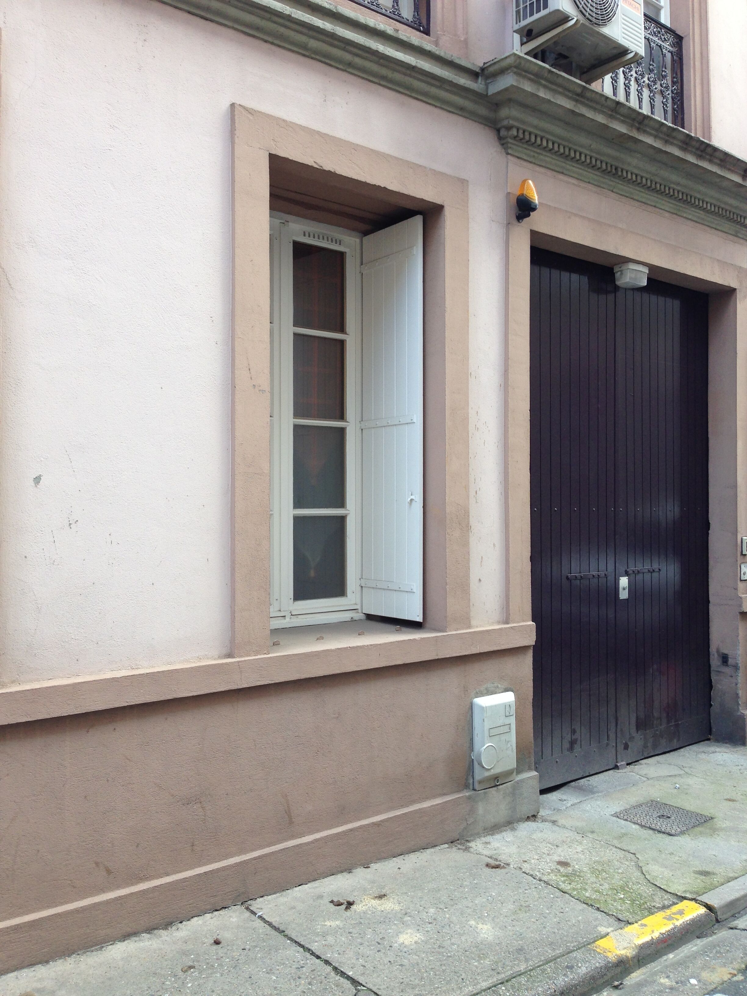 Eine Gebäudefassade mit einem Fenster und einer Tür.